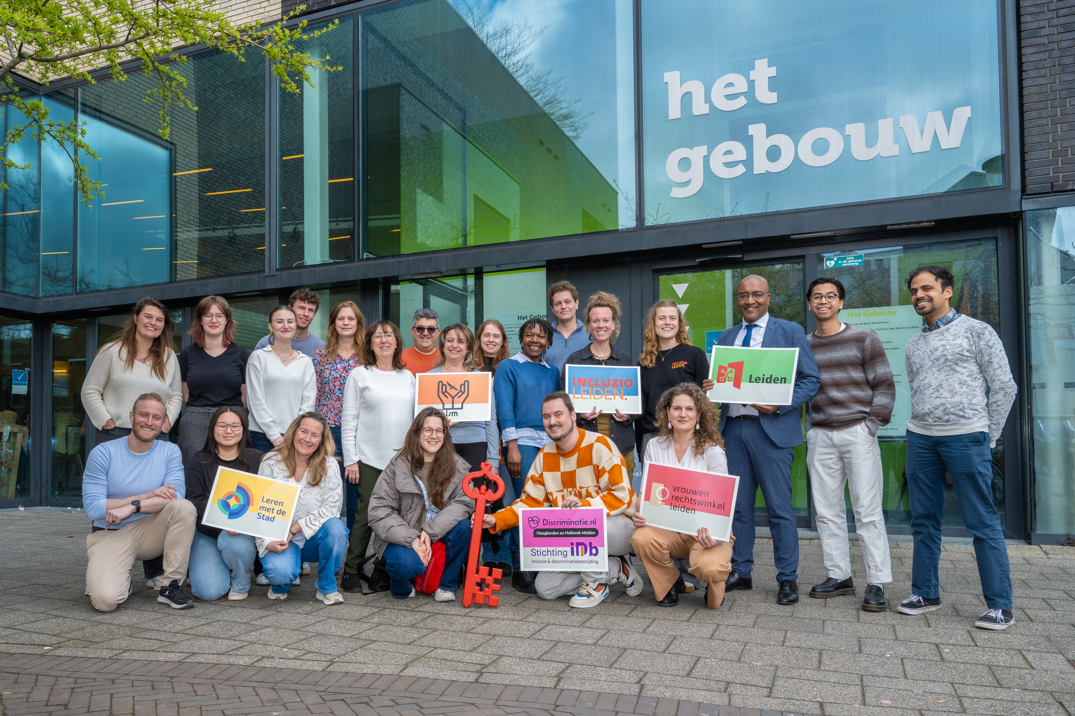 Vrijwilligers van de partnerorganisaties verzamelen buiten een fysieke meldpunt